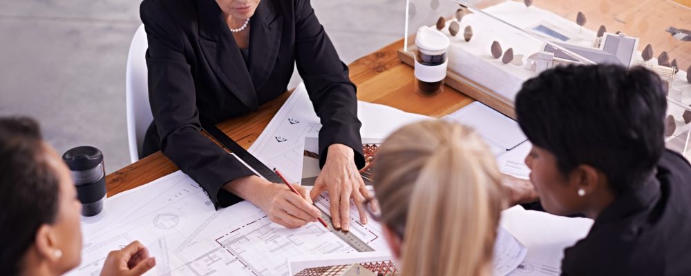 Architects reviewing plans at office desk